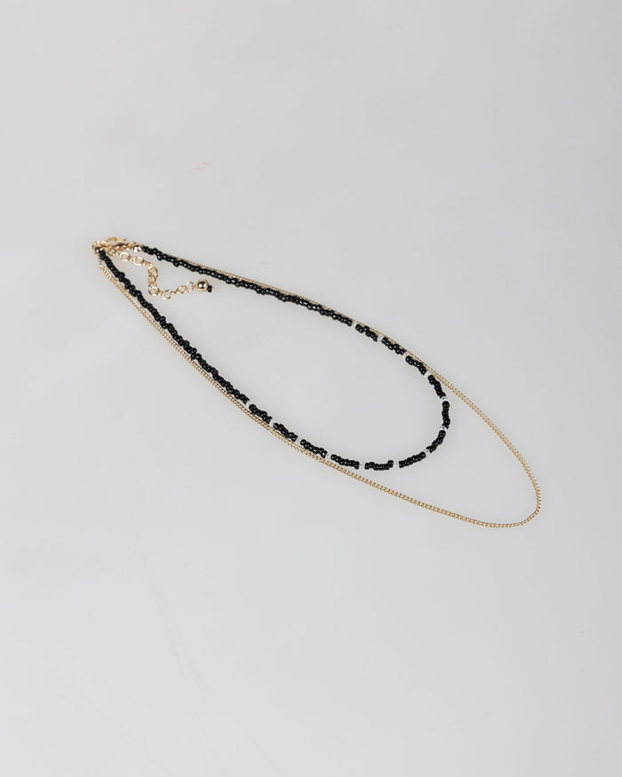 system action Collar doble abalorios negros y cadena color oro En oferta