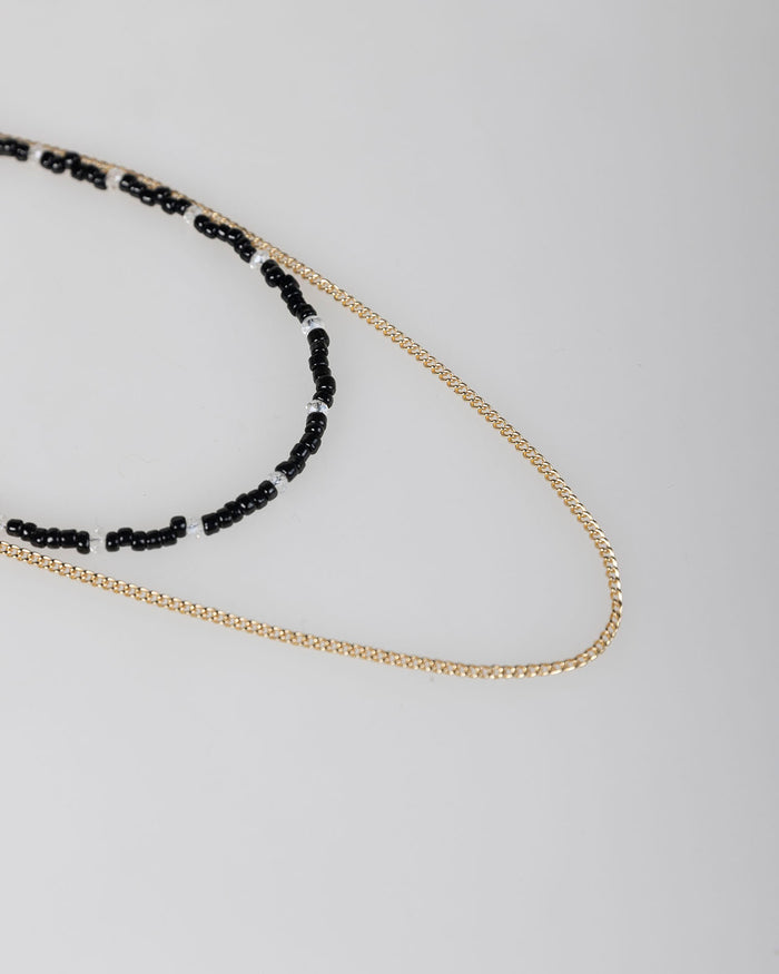 system action Collar doble abalorios negros y cadena color oro En oferta